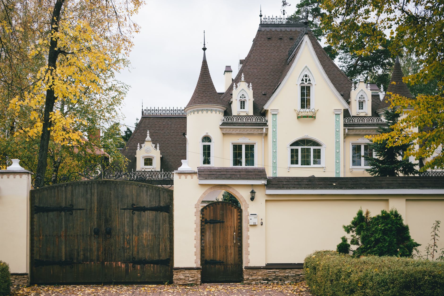 House behind wooden gates surrounded by autumn foliage