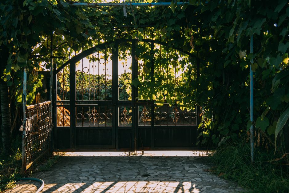 Decorative iron gate between two gate posts