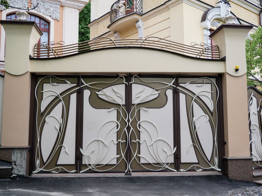 Metal gate with vertical pickets beside a brick wall