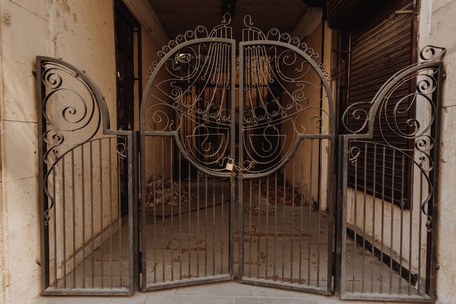 Metal driveway gate with a lock side post